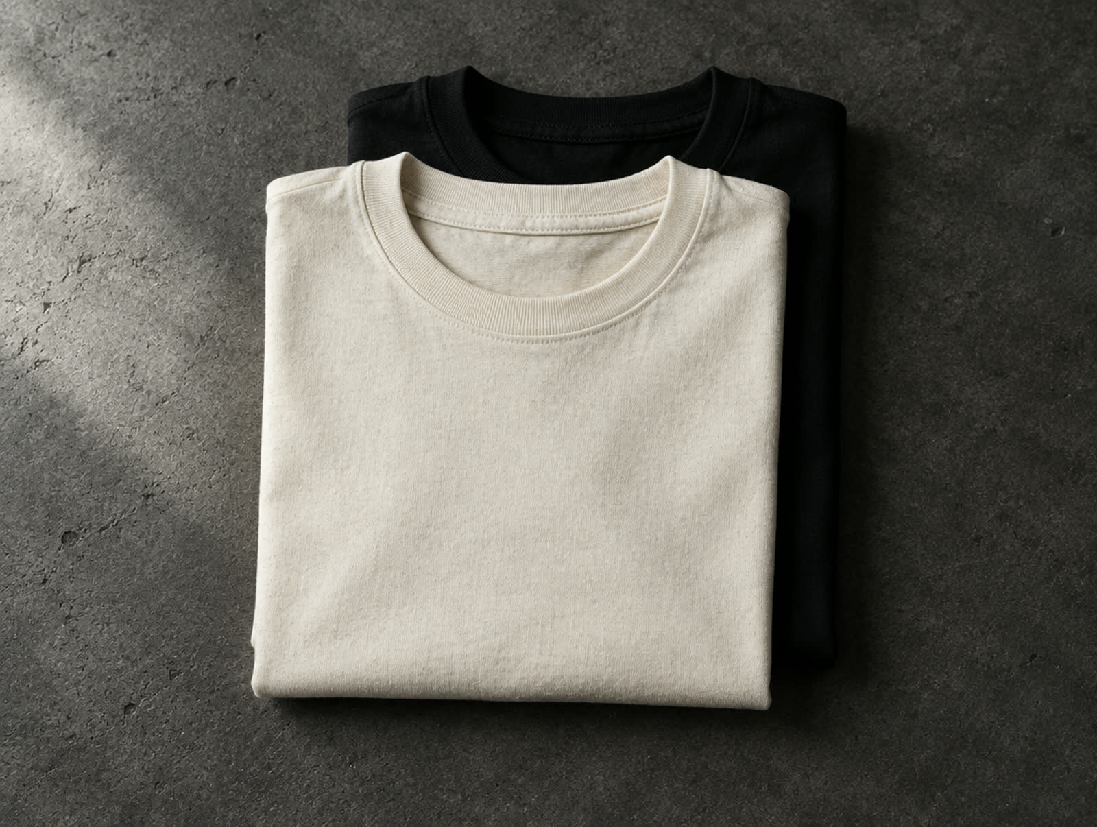 Two folded plain t-shirts, natural and black